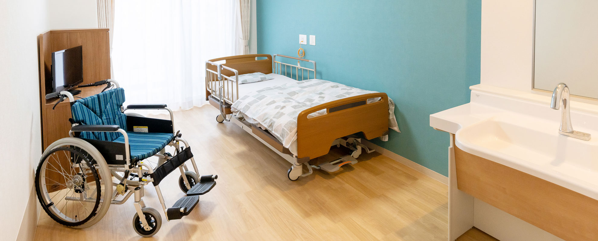 福祉施設の個室の中の様子。ベッドや車いすが設置されている。